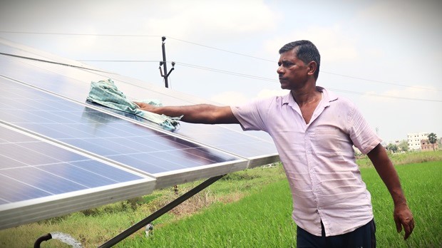 Shashi Bhushan Prasad, a farmer in Nalanda district cleans the solar panel of his solar pump. Photo by-Manish Kumar/Saur Energy
