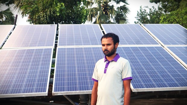 A solar pump user in Ben shows his solar panel setup. Photo by-Manish Kumar/Saur Energy